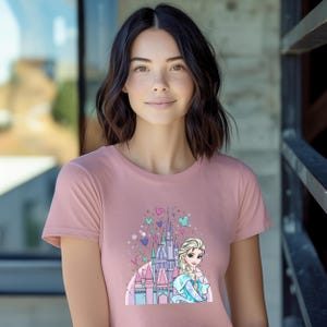 a woman wearing a pink shirt with a castle on it