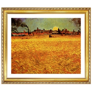May include: A framed print of a landscape painting featuring a field of wheat in the foreground and a town with a setting sun in the background. The artwork is in a gold-colored ornate frame.