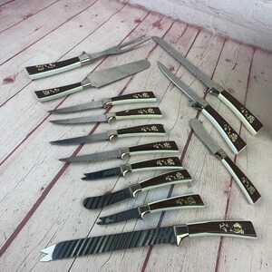 以下が含まれることがあります： 木製の表面に並べられた、茶色と白の柄のついたキッチンナイフ12本セット。ナイフの柄には花柄のデザインが施されています。