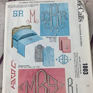 May include: McCall's Transfer Pattern 1803 Multi-Blue. This pattern includes two different styles of letters for monogramming, with sizes ranging from 3.2 cm to 10 cm. The pattern is printed on a white background with blue and red accents.