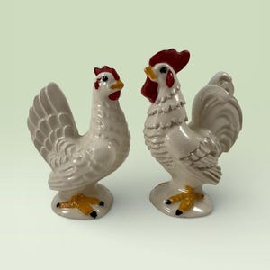 May include: A set of three ceramic mugs with a speckled, matte finish. The mugs are in shades of cream, light gray, and dark gray. Each mug has a simple, minimalist design, perfect for coffee or tea.