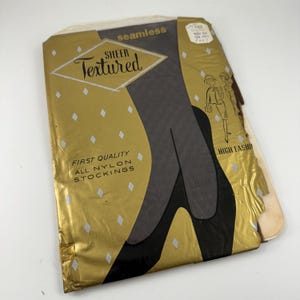 Puede incluir: Un paquete dorado y blanco para medias de nylon transparentes, texturizadas y sin costuras. El paquete presenta un dibujo de una pierna de mujer con las medias puestas y un patrón de diamantes. El texto del paquete dice "Sheer Textured", "First Quality All Nylon Stockings", y "High Fashion".
