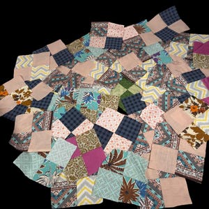 Puede incluir: Una colección de cuadrados de tela coloridos en varios patrones y colores, incluyendo rosa, azul, verde y diseños florales. Los cuadrados están dispuestos en un estilo patchwork, creando una composición texturizada y visualmente atractiva. El tema general es un textil vintage o hecho a mano.