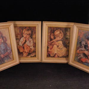 Può includere: Set di quattro stampe vintage incorniciate con bambini. Ogni stampa raffigura un bambino con un'espressione e una posa diverse. Le stampe sono in una cornice di legno chiaro con un passe-partout bianco.
