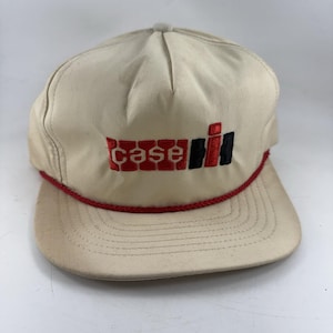 Op de afbeelding: Een witte keramische mok met een zwart handvat en de tekst "But First, Coffee" in een vetgedrukte, zwarte letter. De mok staat tegen een vage achtergrond, wat een gezellige setting suggereert.