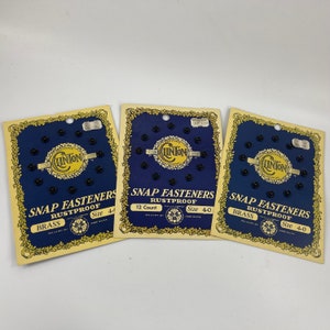 May include: Three cards of black snap fasteners, each with a blue and gold label that reads "Linton Snap Fasteners Rustproof" and "Size 4-0". The center card also reads "12 Count".