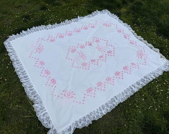 Vintage roze tafelkleed met bloemenborduursel en gegolfde kanten rand