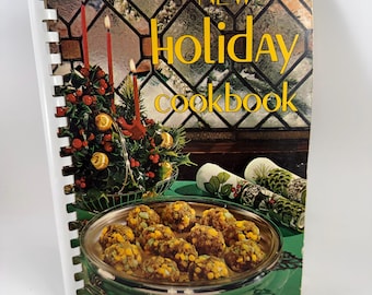 May include: A vintage cookbook titled "New Holiday Cookbook" with a spiral binding. The cover features a festive scene with a Christmas tree, lit candles, and a silver platter of food. The text "Favorite Recipes of Home Economics Teachers" is also visible.