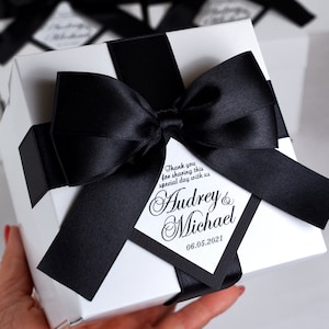 Gepersonaliseerde bedankdoosjes met satijnen strik en aangepaste namen, elegante zwart-witte doos voor je cadeaus en gunsten voor gasten