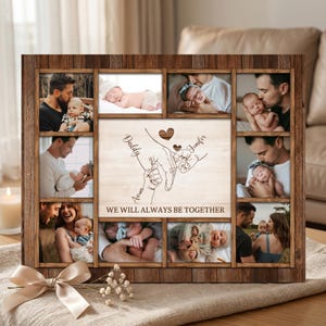 Puede incluir: Un marco de fotos rectangular de madera con diez espacios individuales para imágenes que rodean un panel central. El panel central muestra una ilustración de líneas de manos sosteniendo a un bebé, con el texto "WE WILL ALWAYS BE TOGETHER."
