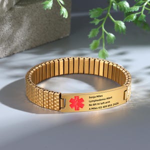 May include: Gold medical alert bracelet with a red star of life symbol and engraved text: Sonja Miles Lymphedema Alert No BP/IV left arm A Miles ICE 409 893 2426