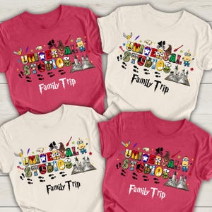 Peut inclure: Quatre t-shirts rouges et crème, chacun orné d'un graphisme coloré. Le motif comprend les mots "UNIVERSAL STUDIOS" et "Family Trip", ainsi que des personnages de dessins animés et une illustration de château. Les t-shirts sont à manches courtes.