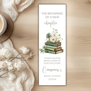 May include: A rectangular bookmark featuring the text THE BEGINNING OF A NEW chapter... above a watercolor illustration of a stack of green books topped with white flowers. Below is the text THANK YOU FOR BEING A PART OF OUR LOVE STORY. Cameron's BRIDAL SHOWER 2/7/2026.