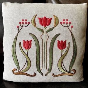 May include: A beige linen pillow with an embroidered design of three red tulips with green leaves and stems. The design is in an Art Nouveau style.