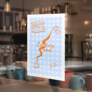 Puede incluir: Un letrero con las palabras "Coming soon" en escritura naranja, con ilustraciones relacionadas con el café. El fondo es azul claro con pequeños círculos azules. El letrero se muestra en un café, con tazas y equipo de café visibles.