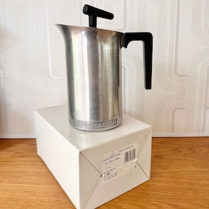 May include: A stainless steel French press coffee maker with a black handle and plunger, sitting on a white box. The coffee maker is branded "Villeroy & Boch". The box has a product information label.