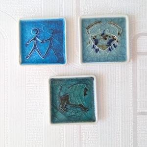 May include: A set of three ceramic nesting bowls in shades of blue, green, and white. The bowls have a speckled glaze and a simple, modern design. The largest bowl is about 15 cm in diameter.