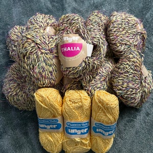 May include: A collection of yarn in yellow and multi-colored hues. The multi-colored yarn is labeled "Unger Thalia" and the yellow yarn is labeled "Plantation Bulky Unger".