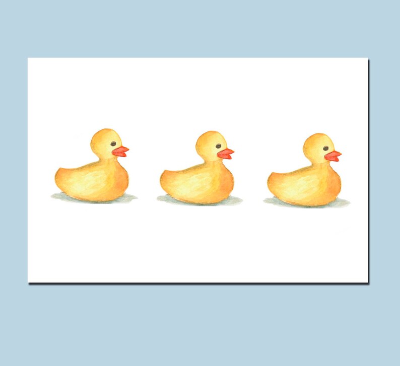 May include: Three yellow rubber duckies with orange beaks, lined up in a row on a white background.