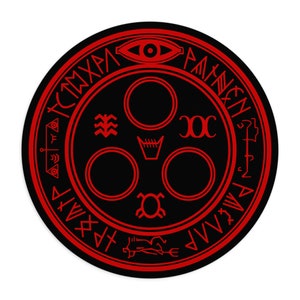 Könnte beinhalten: Ein schwarzes und rotes kreisförmiges Symbol mit einem roten Auge in der Mitte und einer roten Inschrift am Rand. Die Inschrift lautet "TCTMXHA PAMNENN AAPMTP".