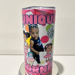 May include: Pink and white tumbler with a personalized design featuring a young girl and the text "UNIQUE" and "CORNE".