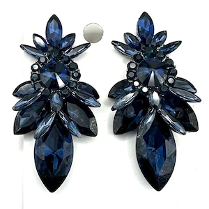May include: A pair of dark blue statement earrings with a cluster of faceted crystals. The earrings have a layered design with a large teardrop-shaped crystal at the bottom. The card reads "Fringe after Dark".