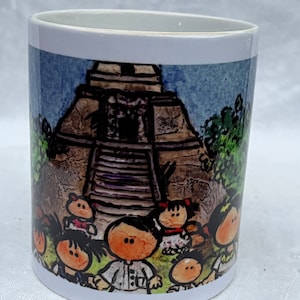 May include: White ceramic mug with a colorful illustration of a Mayan pyramid and cartoon children. The pyramid is brown and gray with steps leading up to the top. The children are wearing colorful clothing and have large eyes.