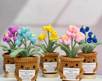 May include: Five crocheted potted plants with different colored flowers. Each pot has a smiling face and a sign that reads "Emotional Support Plant. Life can be tough sometimes, but remember so are you!"