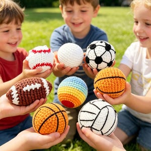 Puede incluir: Una colección de pelotas deportivas de ganchillo hechas a mano, que incluyen una de béisbol, fútbol, baloncesto, fútbol americano y voleibol. Las pelotas son de varios colores y están sostenidas por niños al aire libre. La de béisbol tiene costuras rojas.