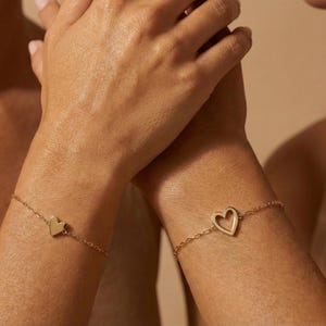 May include: A white ceramic mug with a black handle and the text "But First, Coffee" in a black, handwritten-style font. The mug is on a white surface.