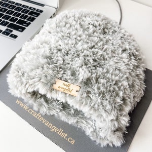 Könnte beinhalten: Ein graues, flauschiges Laptop-Tischunterlage mit einem Holzschild, auf dem "craft evangelist" und die Website-Adresse "www.craftevangelist.ca" steht.