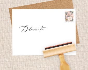 May include: A white envelope with the words "Deliver To" written in black ink. A floral patterned stamp is in the upper right corner. A wooden rubber stamp with a black ink pad is in the lower right corner.