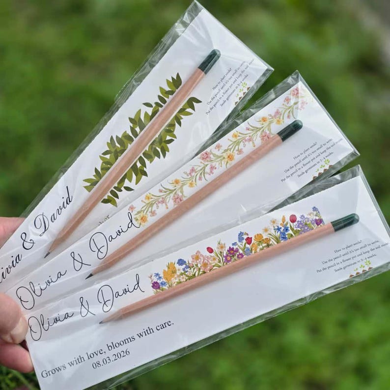 Top-down view of plantable seed pencils attached to custom printed floral cards inside clear plastic sleeves.