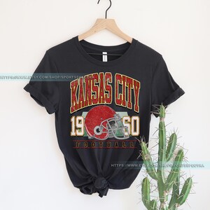 May include: Black t-shirt with a vintage-style graphic of a football helmet and the text "Kansas City 1950 Football".