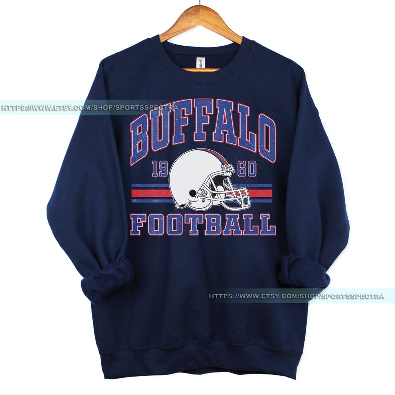Może przedstawiać: Granatowa bluza z nadrukiem w stylu vintage przedstawiającym kask do futbolu amerykańskiego i tekst "Buffalo Football 19 60".