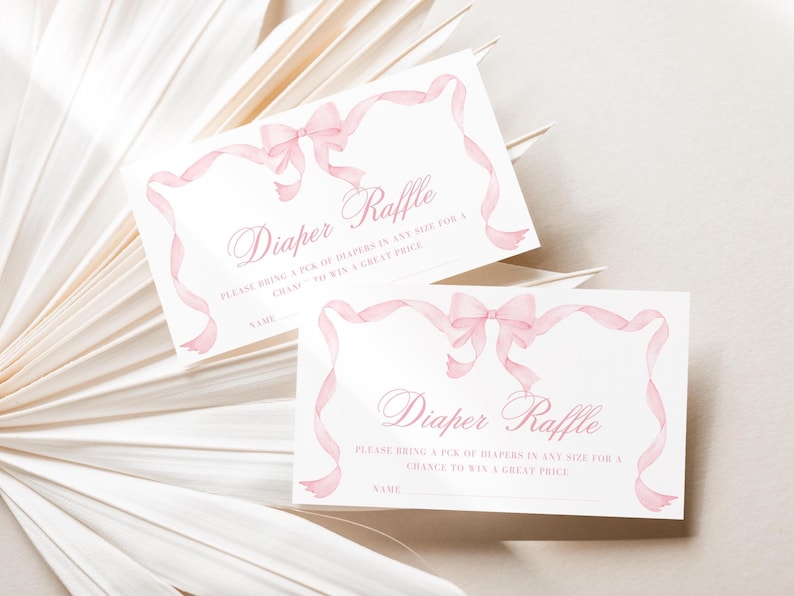 K&ouml;nnte beinhalten: Zwei wei&szlig;e Karten mit rosa B&auml;ndern und Schleifen, die f&uuml;r eine Windel-Tombola entworfen wurden. Die Karten zeigen den Text "Diaper Raffle" in eleganter Schrift, mit Platz f&uuml;r einen Namen.