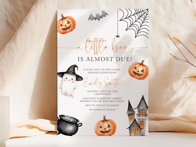 Op de afbeelding: Halloween-thema babyborrel uitnodiging met aquarel illustraties. Met pompoenen, een spook met een heksenhoed, een vleermuis, een spinnenweb en een spookhuis. Tekst luidt "a little boo is almost due!" en bevat evenement details.