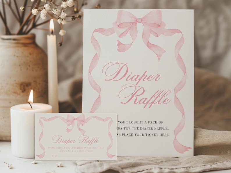 K&ouml;nnte beinhalten: Zwei Karten mit dem Text "Diaper Raffle" in rosa Schrift. Die Karten haben ein Aquarell-Schleifen- und Banddesign in Rosa. Eine brennende Kerze und eine Vase mit Blumen befinden sich im Hintergrund.