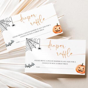 Op de afbeelding: Twee witte Halloween-luierloterijkaarten. Elke kaart heeft een aquarel pompoen, spinnenwebben, vleermuizen en de woorden "diaper raffle" in gouden script. De kaarten bevatten ruimte voor een naam en instructies.