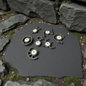 Könnte beinhalten: Eine Sammlung grauer und weißer Unown-Figuren, jede mit einer einzigartigen Form, angeordnet auf einem dunkelgrauen, unregelmäßig geformten Stein. Die Figuren haben einen kreisförmigen weißen Mittelpunkt. Der Hintergrund umfasst Felsen und grüne Vegetation.