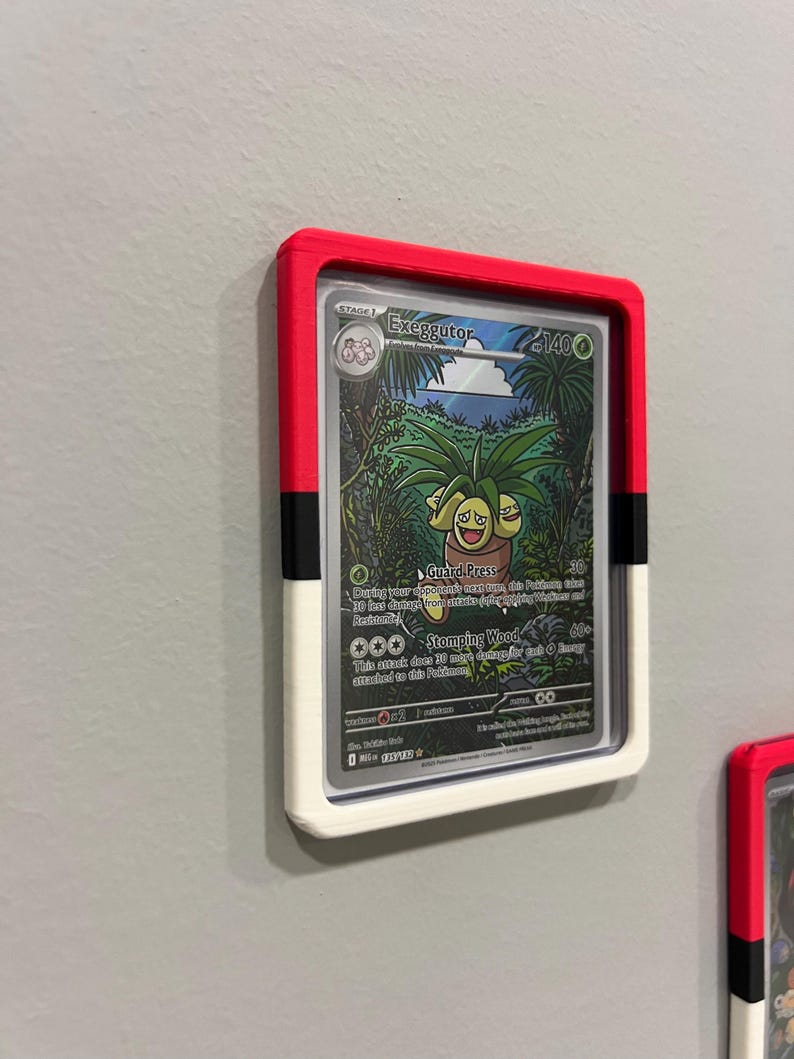 Puede incluir: Una tarjeta coleccionable de Pok&eacute;mon enmarcada con Exeggutor. El marco es rojo, negro y blanco, montado en una pared gris. La tarjeta muestra una colorida ilustraci&oacute;n de Exeggutor en un entorno selv&aacute;tico, con texto que detalla sus habilidades.
