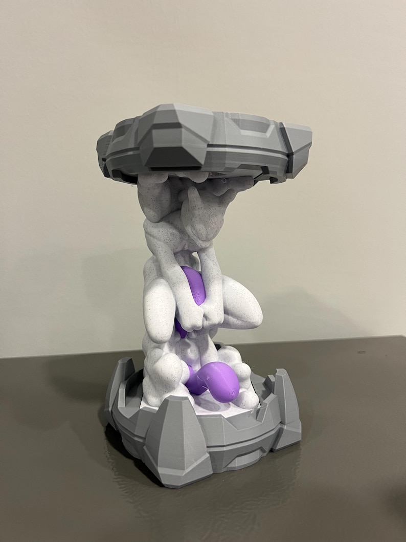 May include: A 3D-printed sculpture featuring a figure supporting a platform. The sculpture is primarily gray and white, with a vibrant purple accent. The design has a geometric and stylized aesthetic, suitable for home decor.