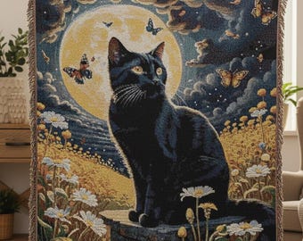 May include: A woven tapestry blanket featuring a black cat sitting in front of a full moon. The design includes butterflies, daisies, and a night sky with clouds. The blanket has a fringed edge.