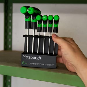 May include: A set of six Pittsburgh star drive wrenches with black and green handles, displayed in a black holder. The holder is labeled "Pittsburgh" and "6 PC 'STAR DRIVE WRENCH SET". The wrenches are on a green shelf.