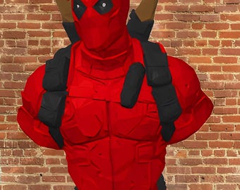 May include: A red bust of a comic book character with a black mask and two brown swords on the back. The bust is on a red base and has black shoulder straps. The background is a brick wall.