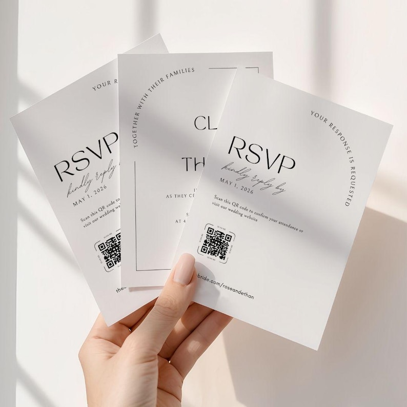 This is a lifestyle image of a womens hand holding three of the wedding invite templates up against a plain white wall. The invites are plain white with bold, classic inspired fonts.
