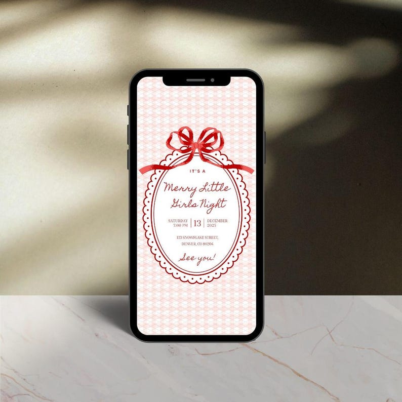 This is a plain, lifestyle mockup of a black phone standing upright with the white and Christmas party for girls night invite in the center.