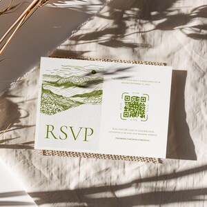 Plain beige background, linen with shadows. In the center of the the lifestyle mock up is a small rectangular RSVP card with beige rope framing it. It is crisp white, with fine line details - in bright white, hand illustrated landscape of the Smokey Mountain National Park. Modern script. A QR code.
