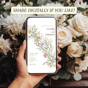 This is a lifestyle mockup photo of a manicured hand holding a phone in front of background of white roses. In the center of the phone screen is an wildflower wedding invite.