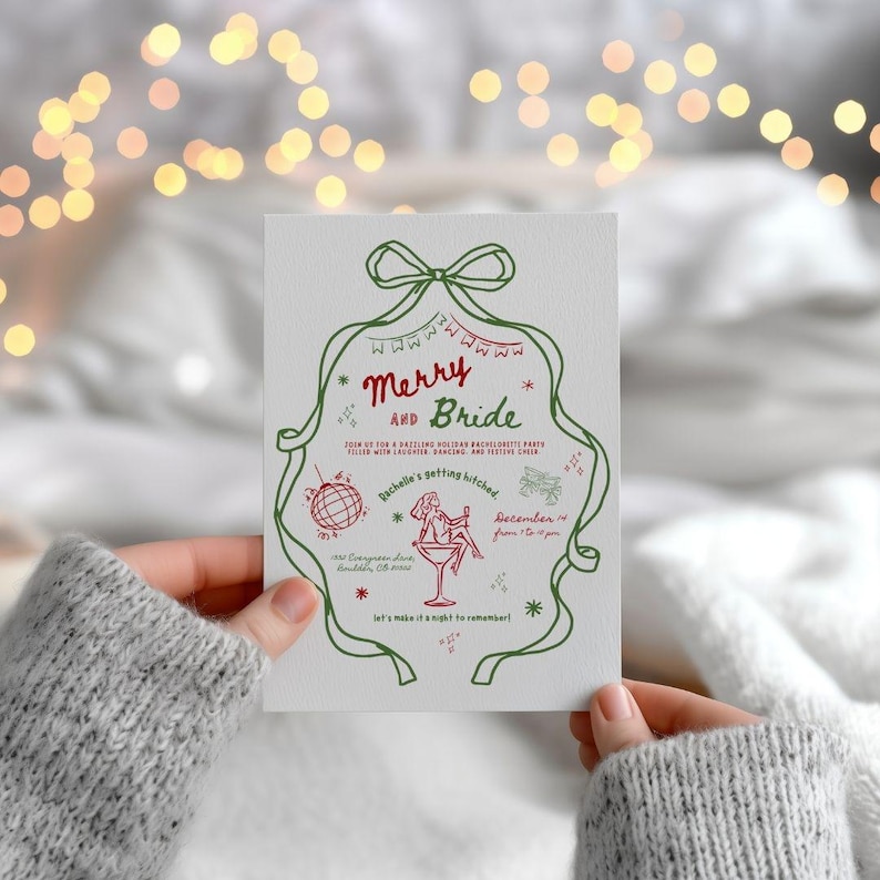 This is a lifestyle mockup photo of a manicured hands holding a Christmas themed Bachelorette party invitation. The mock up has twinkle lights in the background, a soft white blanket, and the hands have a gray knit sweater over her wrists. The Winter bachelorette invitations are crisp white, a green bow, red doodles, and hand drawn font.